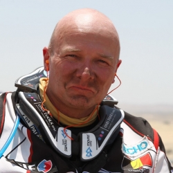 Eric Palante umiera na trasie Dakaru 2014 – Dakar ponownie zebrał śmiertelne żniwo. Wczoraj na trasie piątego etapu zginął belgijski motocyklista Eric Palante i dwóch fotoreporterów z argentyńskiej agencji prasowej.

Belg znaleziony został na 143 kilometrze wczorajszego etapu z Chi­le­ci­to do San Mi­gu­el de Tu­cu­man. Na chwilę obecną nie jest znana przyczyna śmierci motocykli, ani okoliczności związane z tym smutnym zdarzeniem. Organizatorzy i lokalna policja wszczęli dochodzenie w tej sprawie. O ile wiadomo zawodnik nie zgłaszał żadnych problemów, cieszył się dobrym stanem zdrowia, a w dniu wypadku meldował się także na punkcie z wodą. To był 11. Dakar w karierze Palante.

Więcej wiadomo na temat okoliczności śmierci dwóch fotoreporterów. Był to nieszczęśliwy wypadek komunikacyjny. Te niestety są zmorą każdego Dakaru i czasem pochłaniają więcej ofiar wśród ludzi obsługujących rajd i postronnych osób, niż sama rywalizacja na trasie. Tutaj do wypadku przyczyniły się trudne warunki drogowe. Sa­mo­chód z czte­re­ma pra­cow­ni­ka­mi ar­gen­tyń­skiej agen­cji pra­so­wej spadł ze 100 me­trów w szcze­li­nę, a dwóch z nich, sie­dzą­cych na przed­nich sie­dze­niach, po­nio­sło śmierć na miej­scu. Dwaj pozostali poszkodowani prze­trans­por­to­wa­ni zostali do szpi­ta­la w Tu­cu­man. 