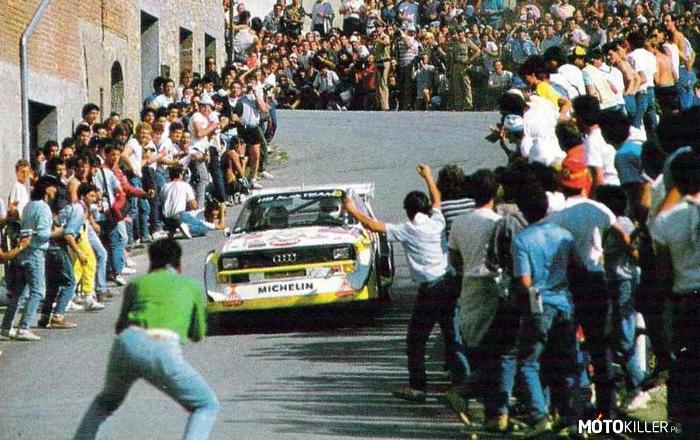 Audi Sport Quattro S1 – Szaleni fani + legendarny potwór

&apos;W roku 1979 Międzynarodowa Federacja Samochodowa (FISA, dziś FIA) dopuściła do serii Samochodowych Rajdowych Mistrzostw Świata pojazdy z napędem na cztery koła. W nowe warunki natychmiast wstrzeliło się Audi ze swoim modelem Quattro, który już w debiucie w portugalskim Rajdzie Algarve startując jeszcze poza klasyfikacją zwyciężył z przewagą aż 27 minut! Wyczyn ten skutecznie zamknął usta wszystkim niedowiarkom twierdzącym, że auta z napędem na cztery koła będą za ciężkie i za mało zwrotne na zakrętach. W roku 1981 Quattro oficjalnie pojawiło się na rajdowych szlakach dając między innymi pierwsze w historii zwycięstwo załodze kobiecej. W roku 1982 Audi wywalczyło tytuł mistrza świata konstruktorów. W tym samym sezonie FISA podjęła decyzję o stworzeniu grupy B, w której niemal niczym nie ograniczeni producenci mogli wystawiać pojazdy, których możliwości porównać można by jedynie do bolidów Formuły 1&apos; 